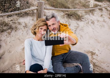 Mature couple taking selfie through smart phone Stock Photo