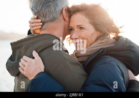 Happy mature woman hugging man on sunny day Stock Photo