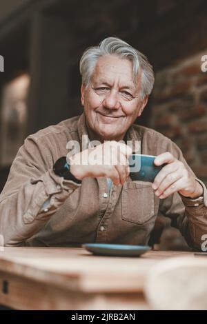 Smiling senior man having coffee in cafe Stock Photo