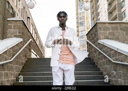 Young man standing in front of steps Stock Photo