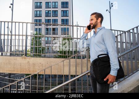 Smiling young businessman talking on smart phone Stock Photo