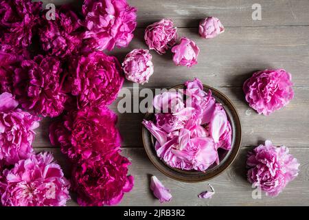 Studio shot of heads of pink blooming peony flowers lying against wooden background Stock Photo