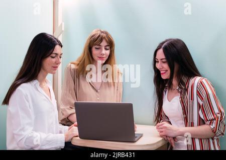 Three businesswomen with laptop having a meeting in office Stock Photo ...