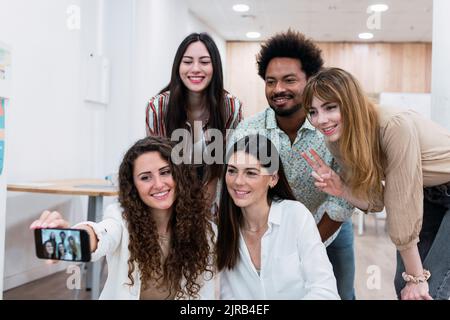 Smiling business team taking selfie in office Stock Photo