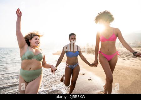 Carefree multiracial women having fun at beach on sunny day Stock Photo
