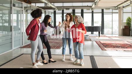 Smiling colleagues gesturing and talking with each other in office Stock Photo