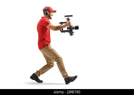 Full length profile shot of a camera operator using a stabilizer and recording with camera isolated on white background Stock Photo
