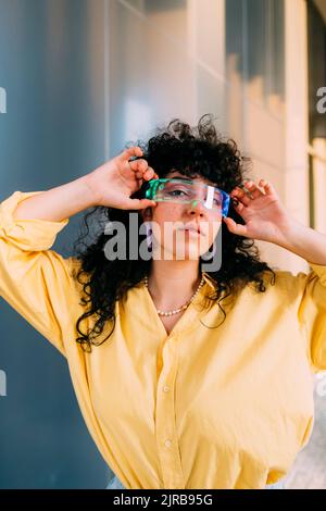 Young woman adjusting cyber glasses Stock Photo