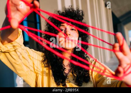 Woman playing cats cradle with thread Stock Photo