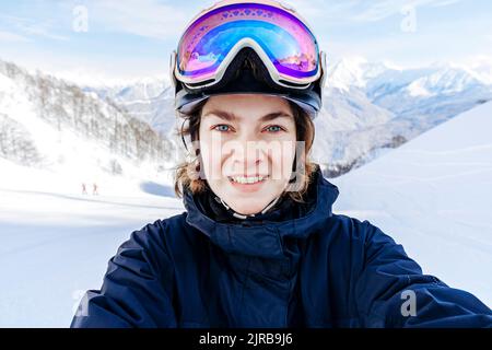 Smiling woman wearing ski goggles Stock Photo