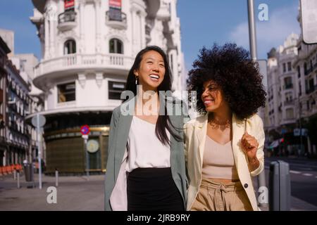 Happy multiracial friends strolling together in city Stock Photo