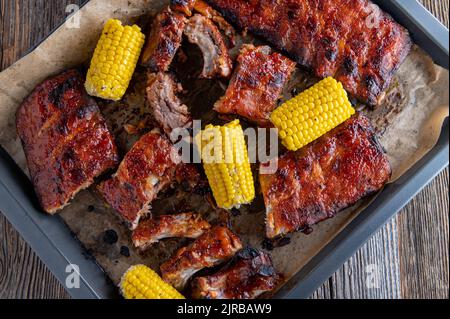 Marinated pork  ribs with corn on the cop on a baking tray Stock Photo