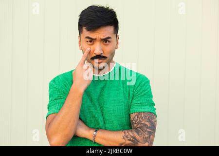 Portrait of young man with moustache, tattooed hand, dreamy face and eyes  closed in front of sunset sky wearing yellow jumper Stock Photo - Alamy