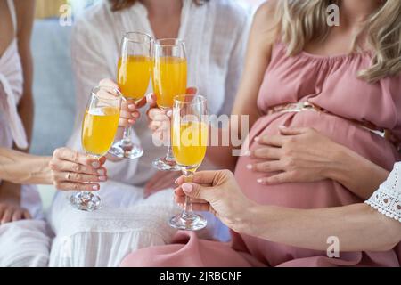 Hands of women toasting cocktail glasses at baby shower Stock Photo