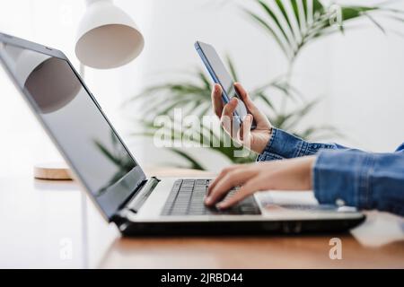 Hands of businesswoman using wireless technologies at home office Stock Photo
