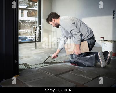 worker applying tile adhesive glue on the floor Stock Photo - Alamy