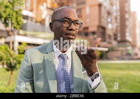 Mature businessman talking on smart phone speaker Stock Photo