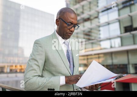 Mature businessman examining documents at financial district Stock Photo