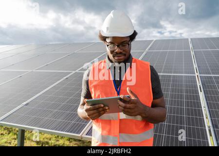 Engineer using tablet PC at solar station Stock Photo