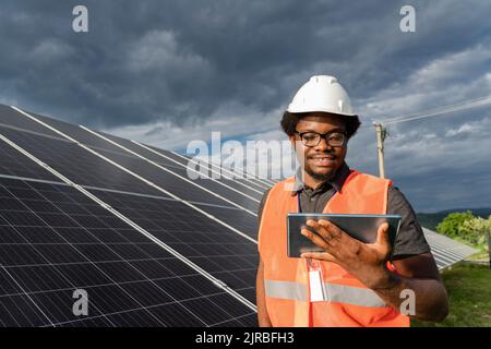 Smiling engineer using tablet PC at solar station Stock Photo