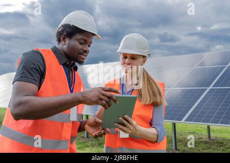 Engineer and co worker sharing tablet PC at solar station Stock Photo