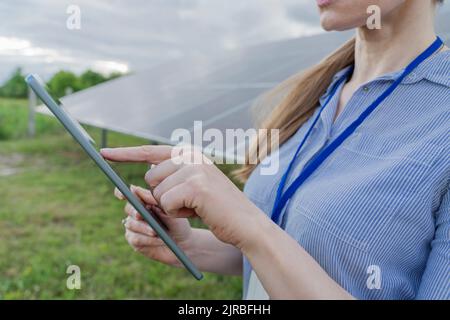 Engineer using tablet PC at solar station Stock Photo