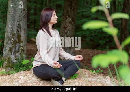 Young woman meditating in forest Stock Photo