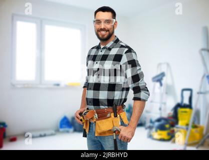 happy male worker or builder with tool belt Stock Photo
