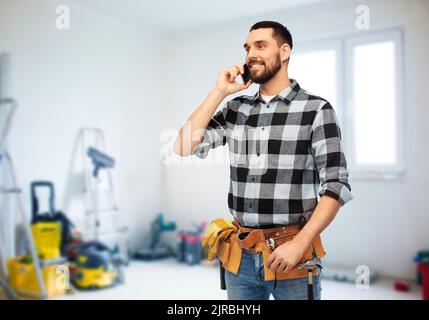 builder in helmet calling on smartphone Stock Photo