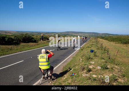 7thAug22 Gower Swansea Wales UK Triathlon Ironman cycling event Cyclists approaching as professional photographer at roadside gets head-on view images Stock Photo