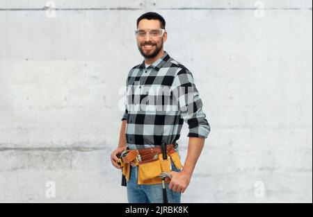 happy male worker or builder with tool belt Stock Photo