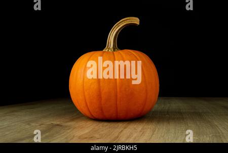 Small decorative autumn pumpkin on a wooden table. Stock Photo