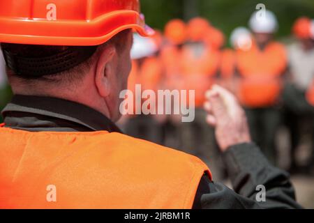Worker group wearing vest, safety. Building concept. Architector, engineers on constructing site. Builder man. Helmet builder. Many construction Stock Photo