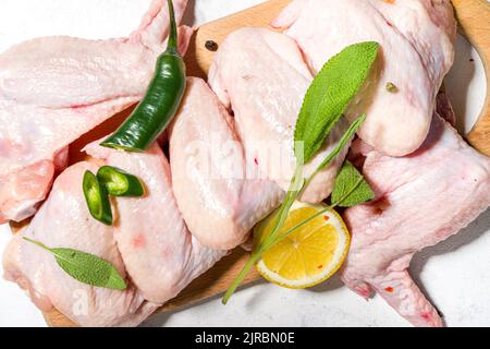 Raw uncooked chicken wings, ready for cooking, bbq, with herbs, vegetable, spices Stock Photo