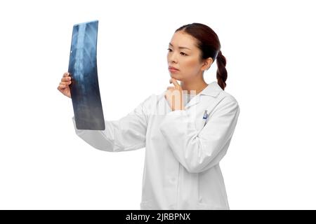 asian female doctor looking at x-ray of spine Stock Photo