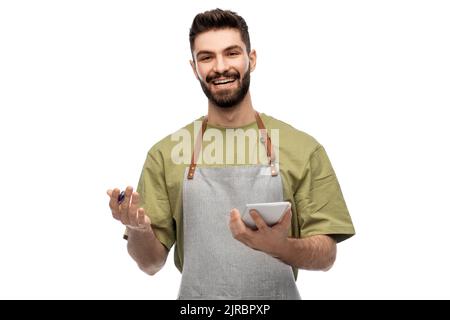 smiling waiter in apron taking notes to notepad Stock Photo