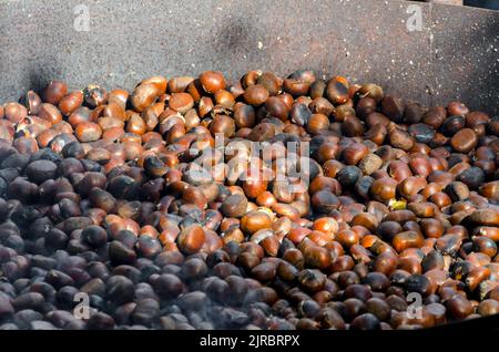 roasted chestnuts cooked on the grill in autumn Stock Photo