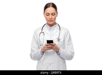 female doctor with stethoscope using smartphone Stock Photo