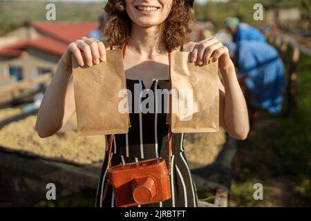 Smiling woman holding two paper bags with coffee beans Stock Photo