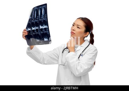 asian female doctor looking at x-ray scan Stock Photo