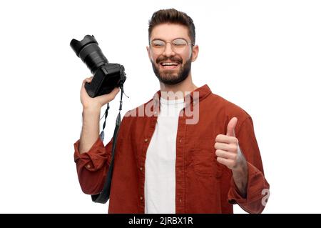 man or photographer with camera showing thumbs up Stock Photo