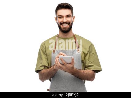smiling waiter in apron taking notes to notepad Stock Photo