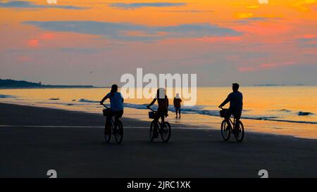 Family riding bikes on the beach on Hilton Head SC , sunrise. Stock Photo