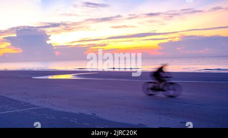 Lone bicyclist on beach early morning, sunrise Hilton Head. Stock Photo