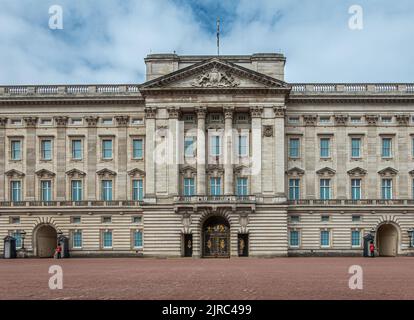 London, England, UK - July 6, 2022: Buckingham Palace beige stone building from one Queen's Guard to another under blue cloudscape. Columned central p Stock Photo