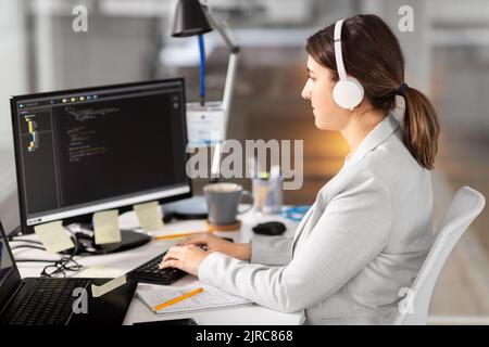 programmer in headphones with computer at office Stock Photo