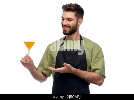 happy barman in apron with glass of cocktail Stock Photo