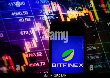 KONSKIE, POLAND - August 10, 2022: Smartphone displaying logo of Bitfinex cryptocurrency exchange on stock exchange diagram background Stock Photo