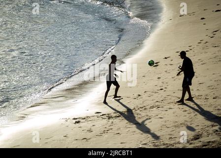 Salvador, Bahia, Brazil - November 01, 2021: Two young men playing beach soccer at Rio Vermelho beach in Salvador, Bahia in the late afternoon. Stock Photo