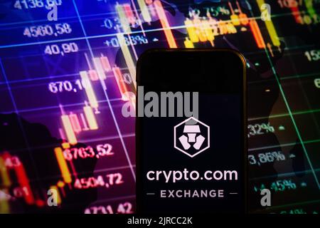 KONSKIE, POLAND - August 10, 2022: Smartphone displaying logo of Crypto.com cryptocurrency exchange on stock exchange diagram background Stock Photo